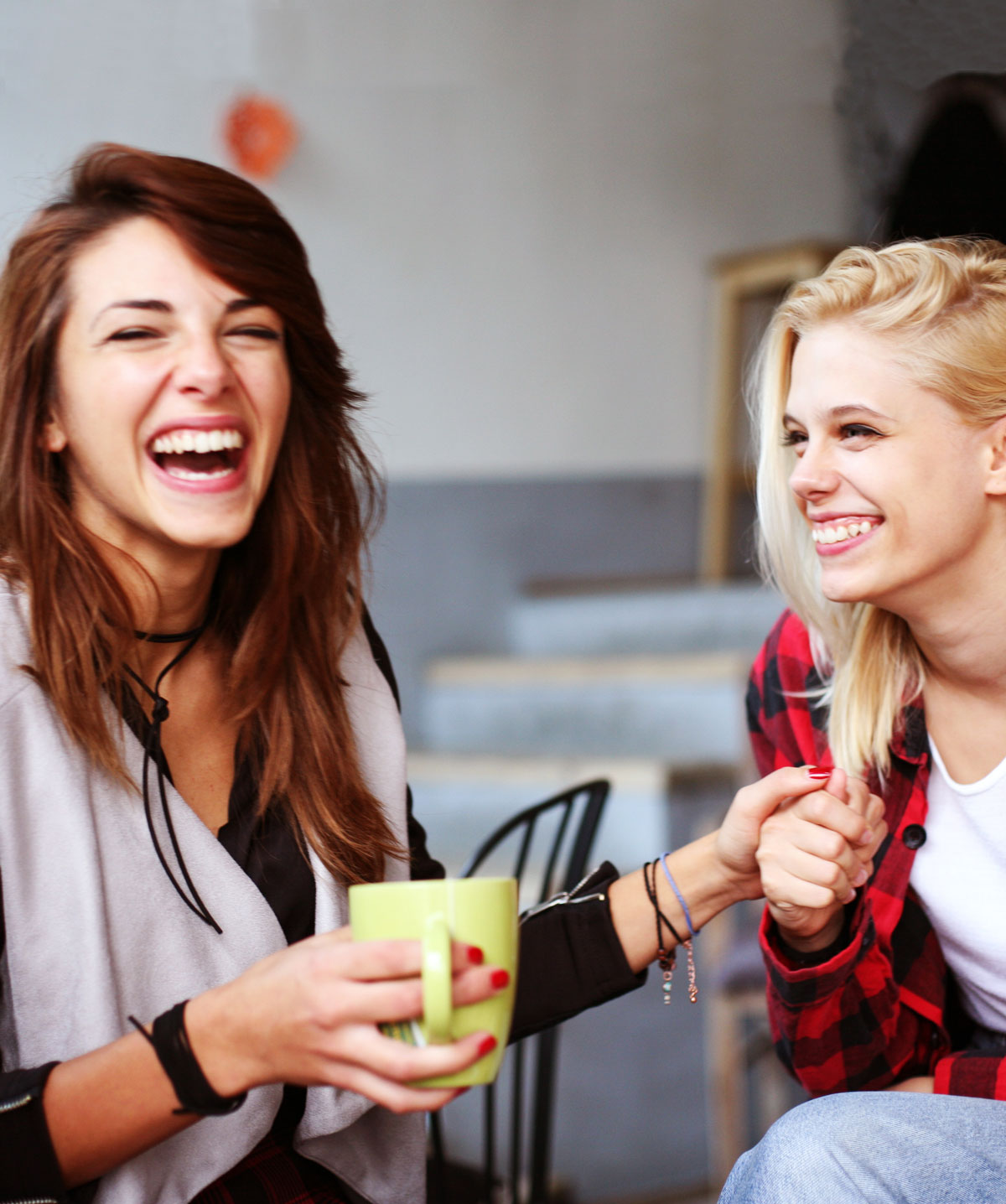 two girls drinking coffee and laughing